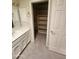 This bathroom has a vanity with sink, a mirror and a closet with built in shelving at 7646 E Miami Rd, Scottsdale, AZ 85258