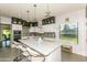 Well-lit kitchen with an island, pendant lights, and white and black cabinets and stainless appliances at 7646 E Miami Rd, Scottsdale, AZ 85258