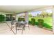 Covered patio with table and chairs overlooking a manicured lawn at 7646 E Miami Rd, Scottsdale, AZ 85258