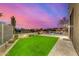 A serene backyard boasts vibrant green turf, cacti, and clear skies, offering an inviting outdoor retreat at 9627 E Adobe Dr, Scottsdale, AZ 85255