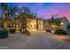 Paver driveway leading to an elegant desert home with lush landscaping, and desert plants at 9627 E Adobe Dr, Scottsdale, AZ 85255