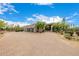 Wide circular driveway leads to a desert home featuring three garage doors and native landscaping at 9627 E Adobe Dr, Scottsdale, AZ 85255