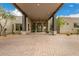 Inviting covered home entrance with stone pillars, desert plants, and elegant exterior lighting at 9627 E Adobe Dr, Scottsdale, AZ 85255