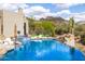 Relax by the stunning pool featuring a rock waterfall, lush landscaping, and mountain views, perfect for Arizona living at 9627 E Adobe Dr, Scottsdale, AZ 85255
