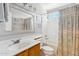Bright bathroom features a single vanity and a shower-tub combo with patterned curtain at 991 W Leah Ln, Gilbert, AZ 85233