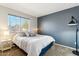 Modern bedroom boasts a dark blue accent wall and large window at 991 W Leah Ln, Gilbert, AZ 85233