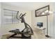 Well-lit exercise room with an elliptical machine and desk setup at 991 W Leah Ln, Gilbert, AZ 85233