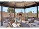 Cozy gazebo with comfortable seating and a stone fireplace, ideal for outdoor entertaining at 991 W Leah Ln, Gilbert, AZ 85233