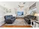 Bright living room features wood floors, a ceiling fan, and comfortable leather furniture at 991 W Leah Ln, Gilbert, AZ 85233