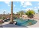 Backyard swimming pool featuring rock accents, a mature palm tree, and a relaxing atmosphere at 991 W Leah Ln, Gilbert, AZ 85233