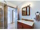 Bathroom featuring a sink, medicine cabinet, glass enclosed shower, and door leading outside at 111 S Greenfield Rd # 611, Mesa, AZ 85206