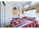Bedroom with a comfortable bed with a southwestern themed blanket, built-in desk, and overhead cabinets at 111 S Greenfield Rd # 611, Mesa, AZ 85206