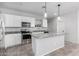 Bright kitchen features granite counters, stainless steel appliances and an island with pendant lighting at 11505 W Boca Raton Rd, El Mirage, AZ 85335