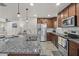 Bright and open kitchen featuring granite countertops, stainless steel appliances, and an island with bar seating overlooking the living area at 1317 N Balboa --, Mesa, AZ 85205