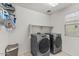 Modern laundry room with front-loading washer and dryer, and a built-in shelf for storage at 1317 N Balboa --, Mesa, AZ 85205