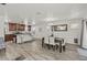 Open-concept living space with a dining area and a kitchen island, featuring wood-look tile floors and a bright ambiance at 1317 N Balboa --, Mesa, AZ 85205