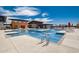 Large community pool with lap lanes, lounge areas, and stylish clubhouse in the background at 13212 E Verbina Ln, Florence, AZ 85132