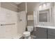 Accessible bathroom featuring a walk-in shower with grab bars and vanity with gray cabinets at 13259 W Flower St, Litchfield Park, AZ 85340