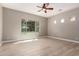 A spacious bedroom features light wood-look floors, natural light, and a modern ceiling fan, creating a serene atmosphere at 13259 W Flower St, Litchfield Park, AZ 85340