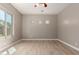 A well-lit bedroom showcases modern recessed lighting, wood-look floors, and three unique windows, enhancing its appeal at 13259 W Flower St, Litchfield Park, AZ 85340