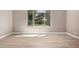 A naturally lit room features wood-look flooring and a large window offering a view of the outdoor landscape at 13259 W Flower St, Litchfield Park, AZ 85340