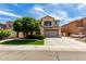 Two-story home featuring desert landscaping, two-car garage, and neutral color scheme under a bright blue sky at 13259 W Flower St, Litchfield Park, AZ 85340