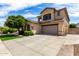 Two-story home featuring desert landscaping, a large driveway, two-car garage, and neutral color scheme at 13259 W Flower St, Litchfield Park, AZ 85340