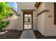 Home featuring a secured, gated front entryway, desert landscaping, sconce lighting, and neutral colored stucco at 13259 W Flower St, Litchfield Park, AZ 85340
