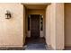 Home featuring a covered front porch with a traditional dark wood door and desert landscaping at 13259 W Flower St, Litchfield Park, AZ 85340