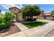 Charming single-story home with desert landscaping, walkway, and a healthy, mature shade tree at 13259 W Flower St, Litchfield Park, AZ 85340