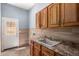 Functional laundry room with ample cabinet space, sink, and exterior door at 13259 W Flower St, Litchfield Park, AZ 85340