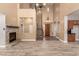 Spacious open-concept living room featuring a fireplace, tile floors, a staircase, and large front door at 13259 W Flower St, Litchfield Park, AZ 85340