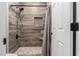 Walk-in shower with gray tiling, niche and black shower head at 13259 W Flower St, Litchfield Park, AZ 85340