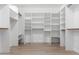Spacious walk-in closet featuring custom shelving and wood-look floors, optimizing storage and adding style at 13259 W Flower St, Litchfield Park, AZ 85340