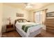 Cozy bedroom featuring a comfortable bed, ceiling fan, wooden floors, and bright natural light at 13421 W Ocotillo Ln, Surprise, AZ 85374