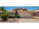 Charming single-story home with a well-maintained front yard, desert landscaping, and a two-car garage at 13421 W Ocotillo Ln, Surprise, AZ 85374
