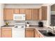 Efficient kitchen setup with wood cabinets, white appliances, and neutral countertops at 13421 W Ocotillo Ln, Surprise, AZ 85374