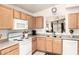Well-lit kitchen boasts ample cabinetry, white appliances, and a pass-through window at 13421 W Ocotillo Ln, Surprise, AZ 85374