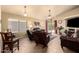 Spacious living room with a ceiling fan, tile flooring, and sliding glass doors to the backyard at 13421 W Ocotillo Ln, Surprise, AZ 85374