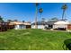 Spacious backyard featuring lush green grass, a patio with seating, solar panels, and a play set at 14008 N 61St Ave, Glendale, AZ 85306