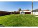 Lush backyard with grassy lawn, play structure, and storage shed at 14008 N 61St Ave, Glendale, AZ 85306