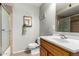 Bathroom with tiled shower, framed mirror, single sink vanity, and tile floors at 14008 N 61St Ave, Glendale, AZ 85306