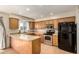 Well-lit kitchen features wood cabinets, stainless steel appliances, tile floors and a breakfast bar at 14008 N 61St Ave, Glendale, AZ 85306