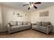 Inviting living room featuring neutral-toned sofas, a ceiling fan, and tile flooring at 14008 N 61St Ave, Glendale, AZ 85306