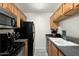 Efficient kitchen with black appliances, wood cabinetry, and ample counter space at 14203 N 19Th Ave # 1031, Phoenix, AZ 85023