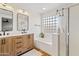 Bathroom with double sinks and a soaking tub with a shower behind glass bricks at 1462 E Poncho Ln, San Tan Valley, AZ 85143