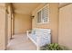 Inviting covered front porch with a white bench and decorative potted plants at 1462 E Poncho Ln, San Tan Valley, AZ 85143