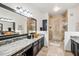 Bathroom featuring dual sinks, granite countertops, and a glass-enclosed shower at 15380 N 100Th St # 1124, Scottsdale, AZ 85260