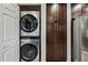 Convenient laundry area with a stacked washer and dryer and dark wood storage at 15380 N 100Th St # 1124, Scottsdale, AZ 85260