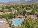 Aerial view of a community pool with mountain views, surrounded by trees and buildings at 15380 N 100Th St # 1124, Scottsdale, AZ 85260